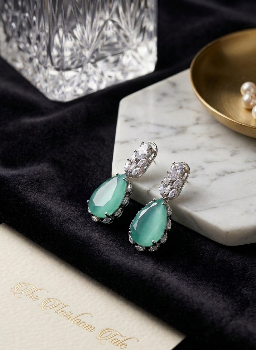 Teal earrings with silver accents on a marble surface