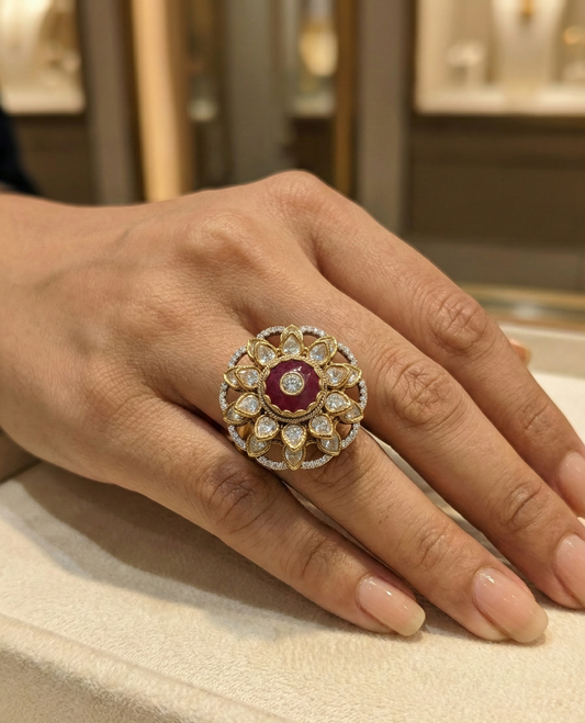 Gold ring with a red gemstone on a hand, with a blurred jewelry store background