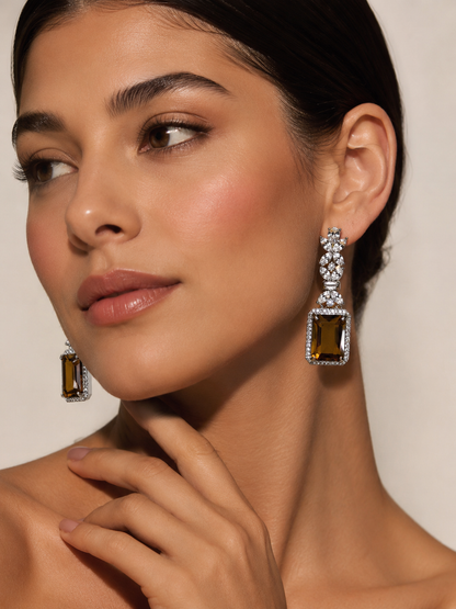 Close-up of a woman wearing sparkling earrings against a neutral background